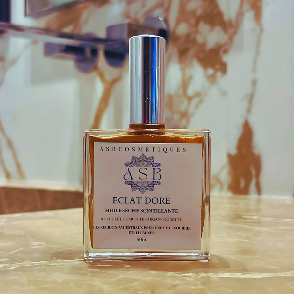 flacon en verre de 50ml d'une huile sèche scintillante éclat doré ASB cosmétiques poser sur le plans de travail de la salle de bain 